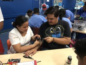 ASCC marine science student teaches a high school student how to build a circuit during a ROV outreach event