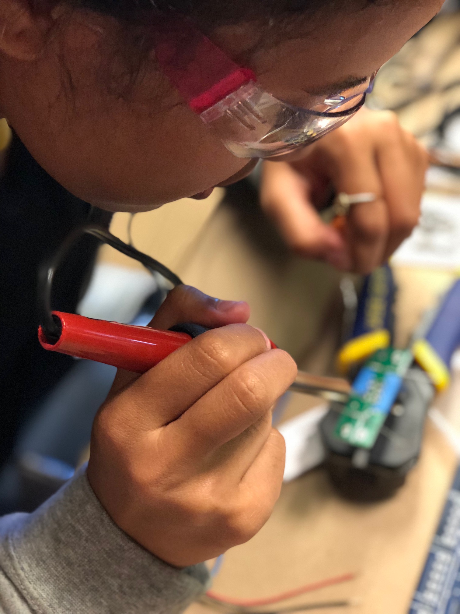 PCC Marine Science Student Solders Wires On A Circuit Board.